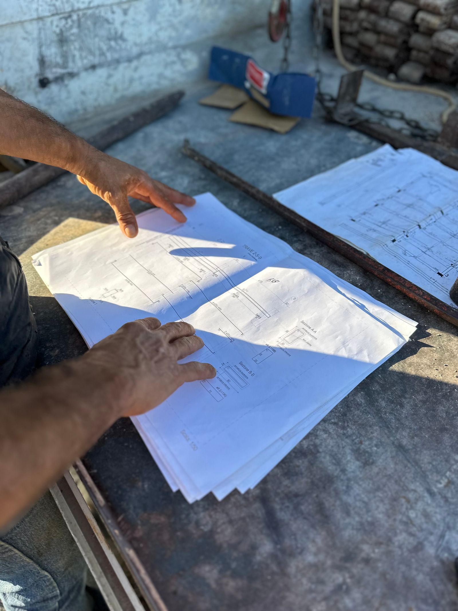 Hands reviewing building plans at a worksite