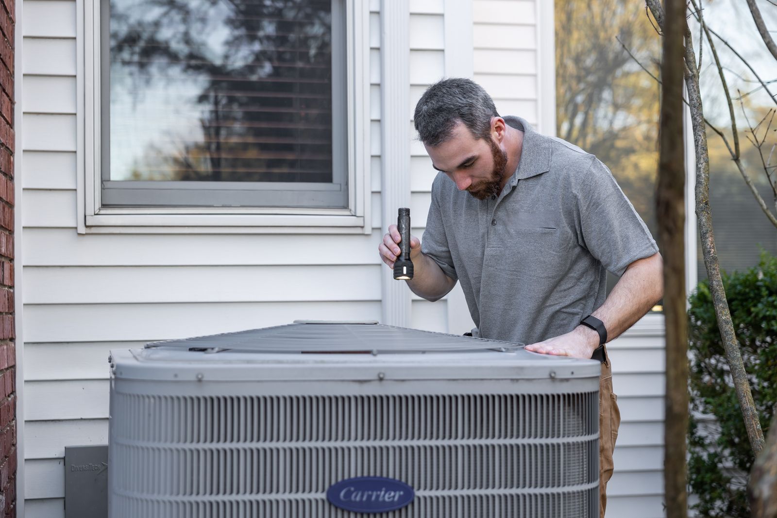 Person inspecting an outdoor HVAC unit