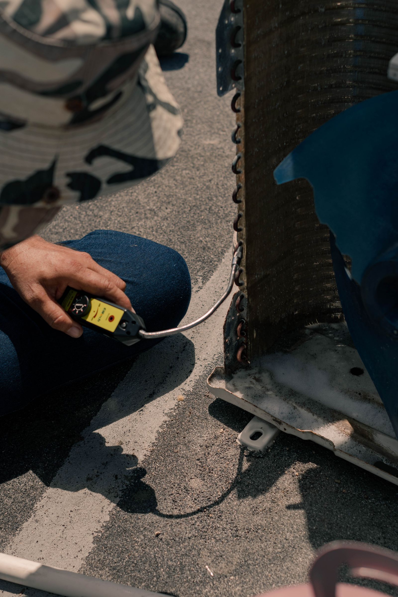 Hands working on an air-conditioning unit