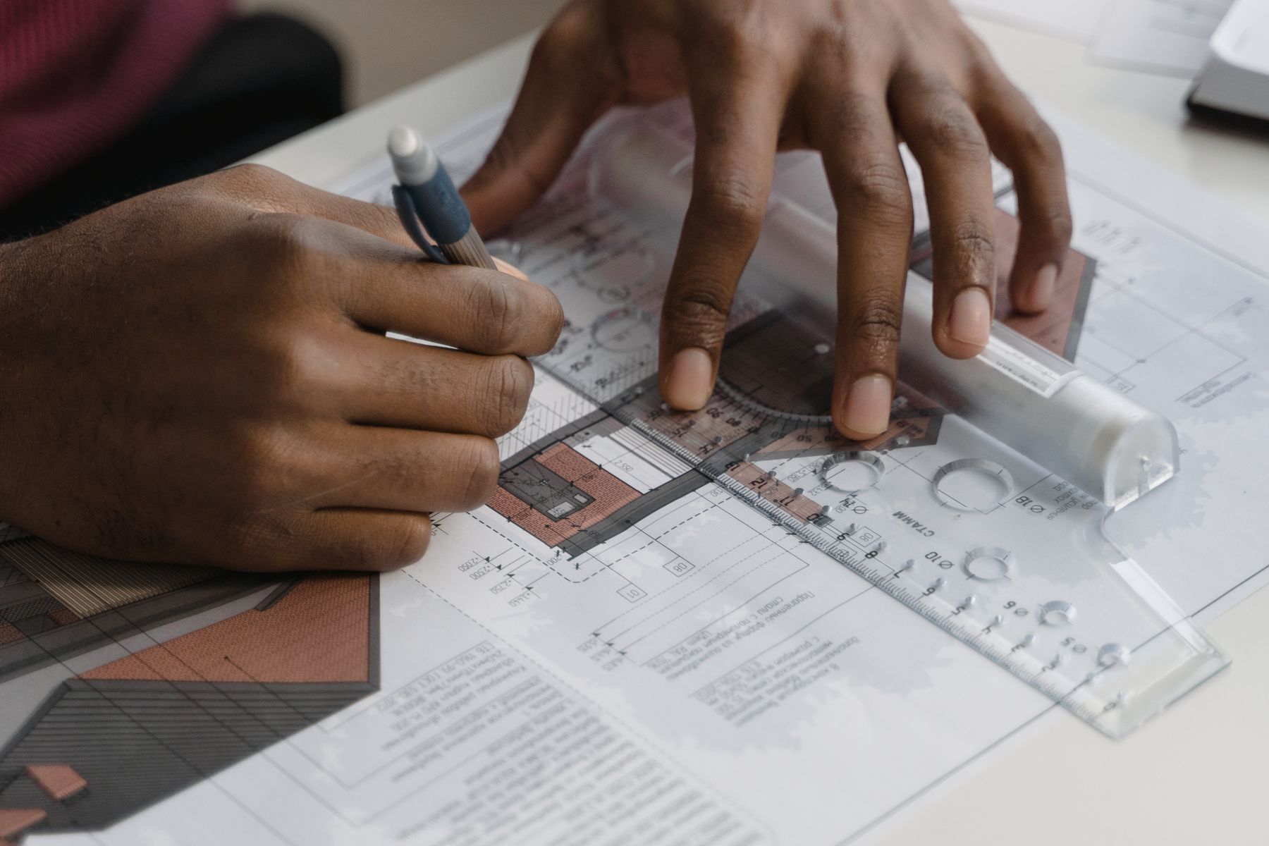 Hands working with plans and ruler