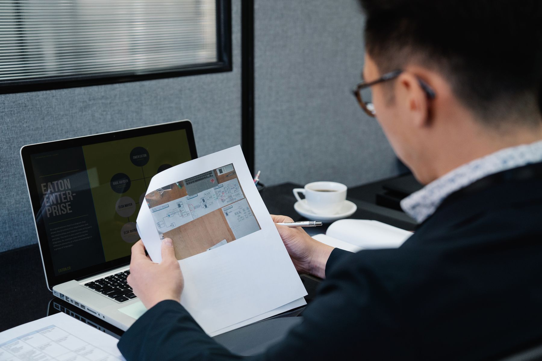 Person reviewing documents beside a laptop