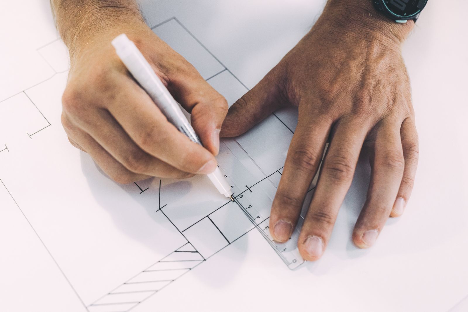 Hands using a ruler on a building layout